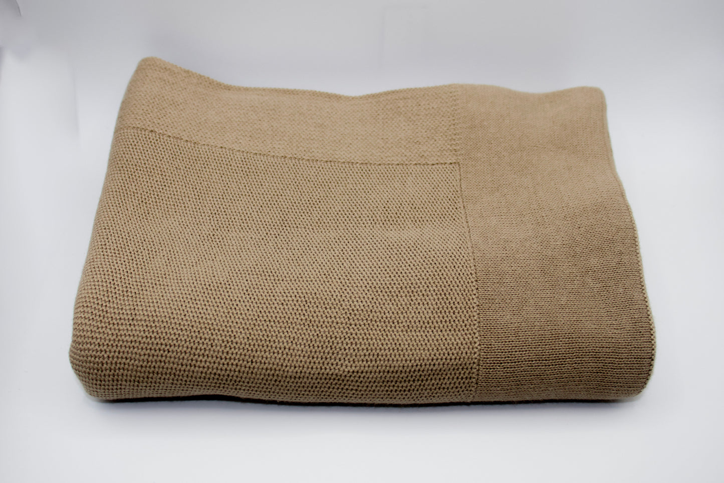 Folded brown blanket on a white background