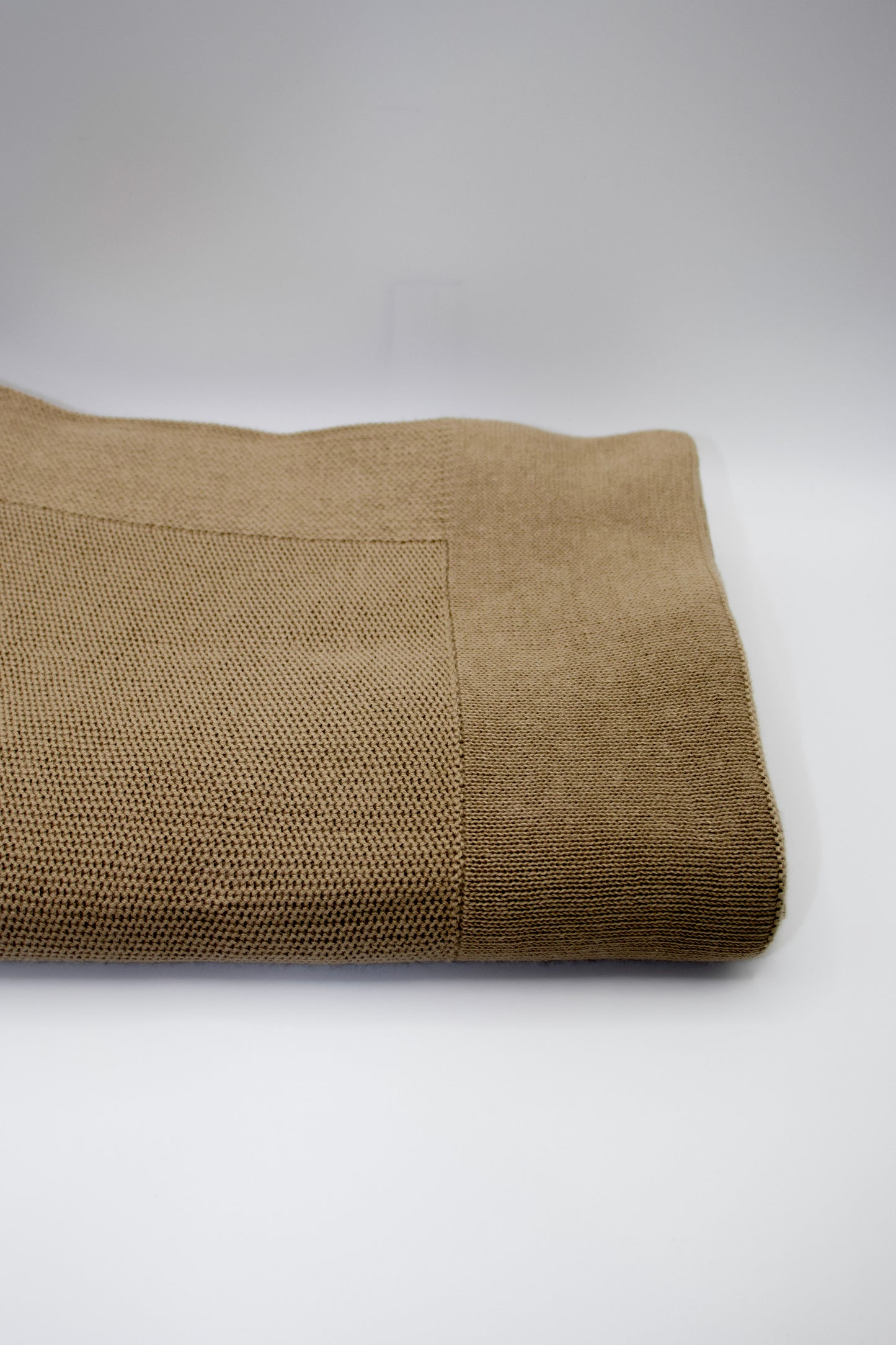 Folded brown blanket on a white background