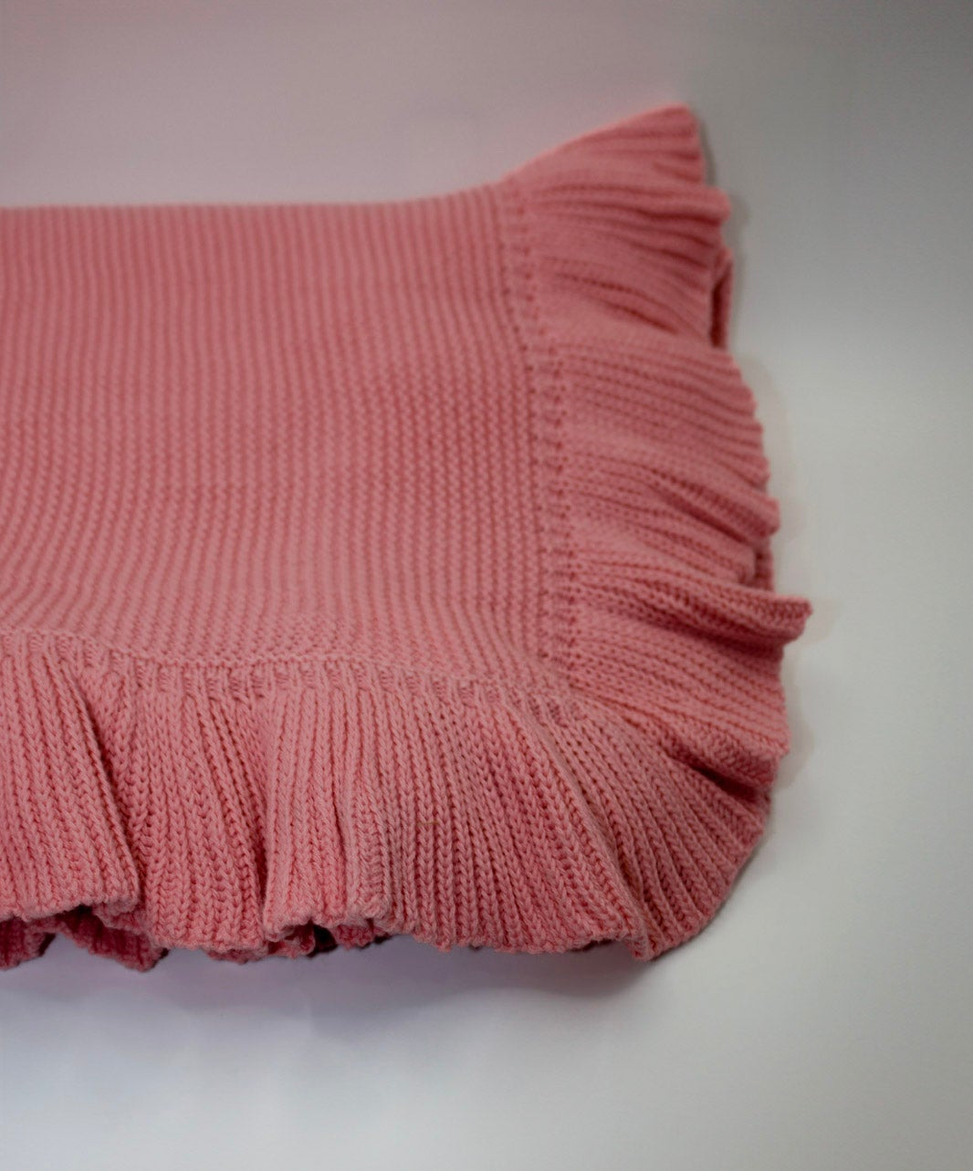Pink knitted blanket on a white background