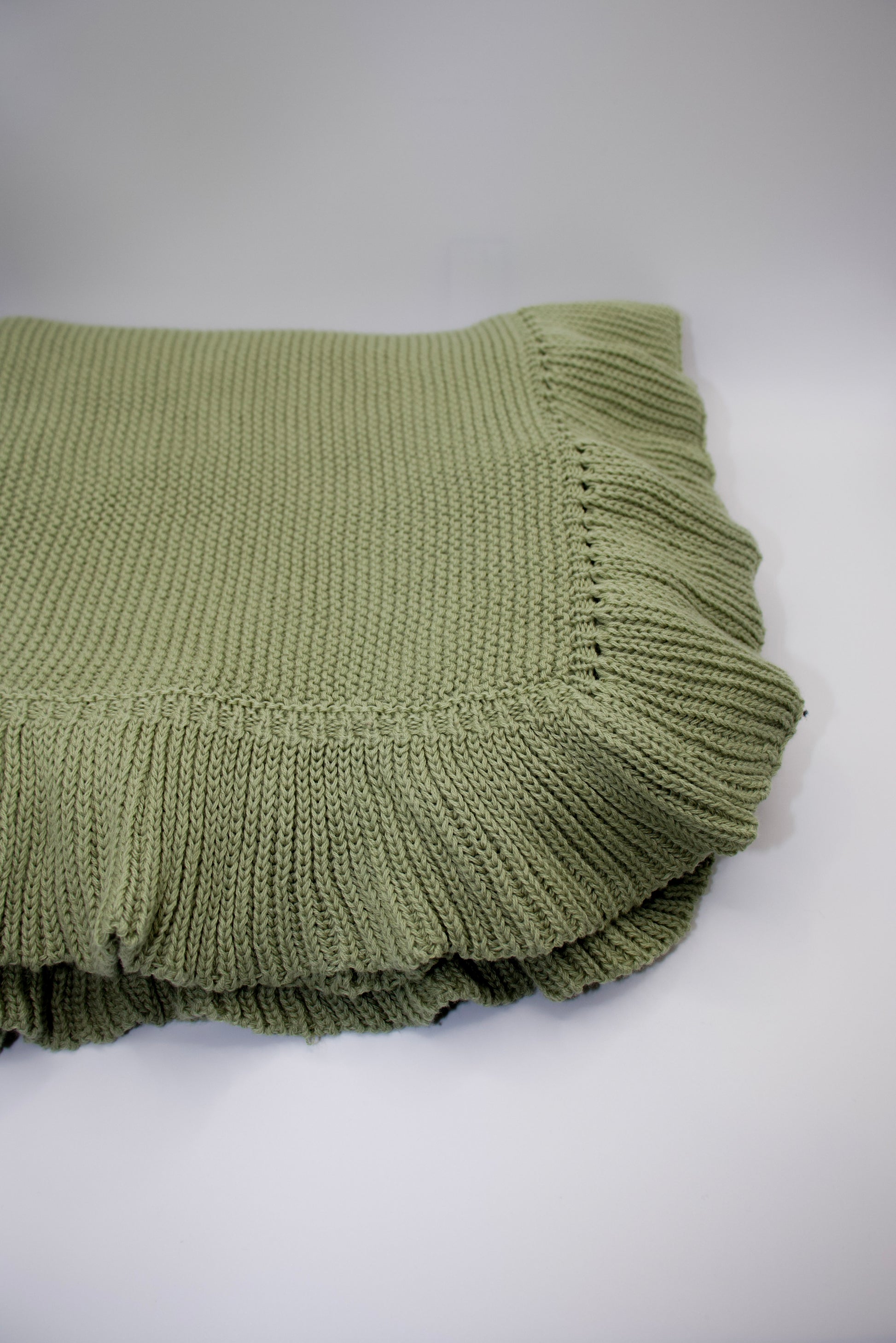 Green knitted blanket on a white background