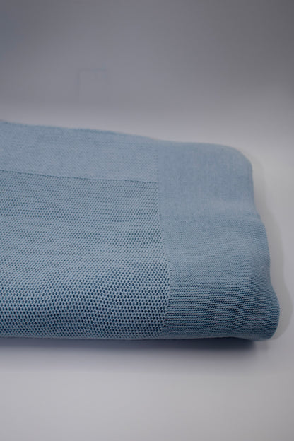 Rolled-up blue fabric on a gray background