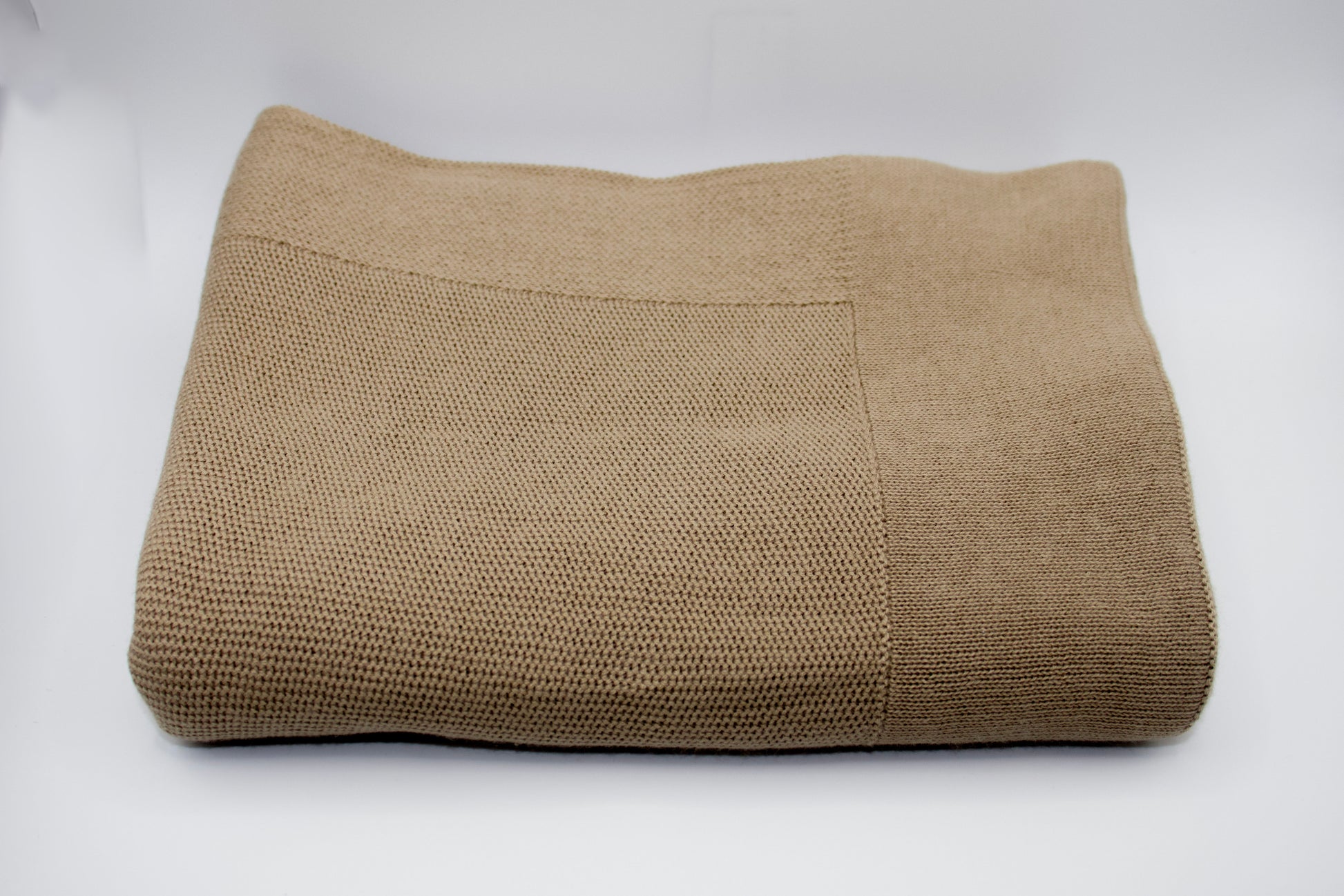 Folded brown blanket on a white background