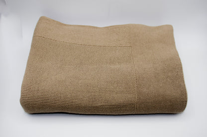 Folded brown blanket on a white background